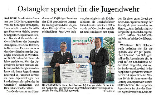 Herr Rohwer (Vorstandsvorsitzender Ostangler) übergibt einen Spendenscheck an die Kappelner Jugendfeuerwehr.